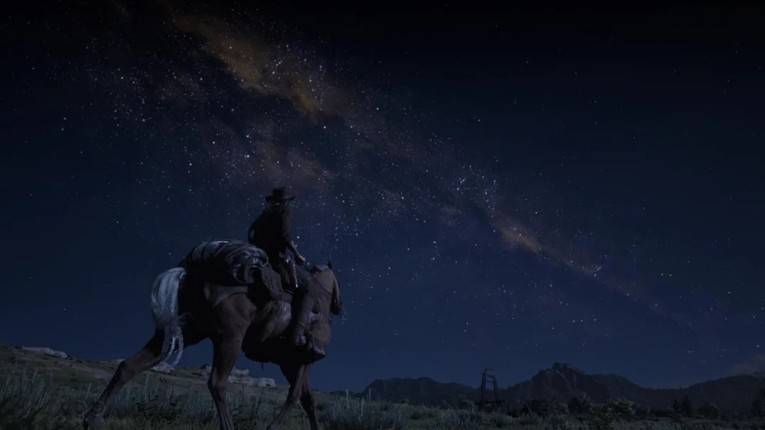 Red Dead Redemption 2's night sky portraying the Milky Way as a brown band with monochromatic stars.
